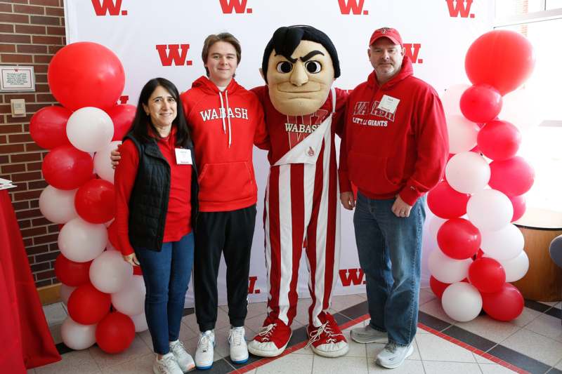 a group of people posing for a photo with a mascot