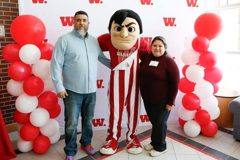 a man and woman posing with a mascot