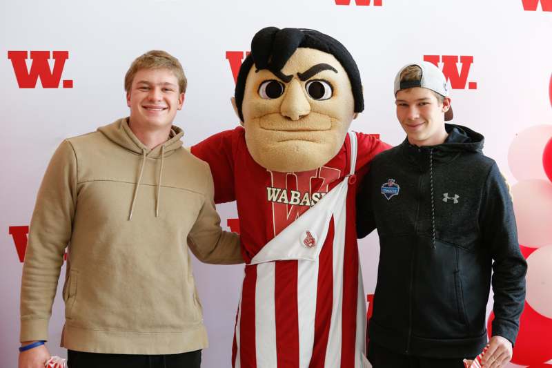 a group of men posing with a mascot