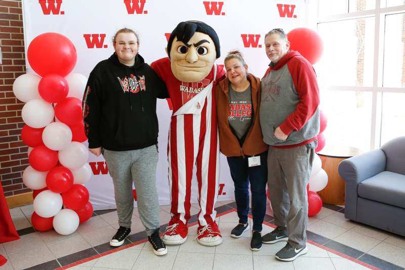 a group of people posing for a picture with a mascot