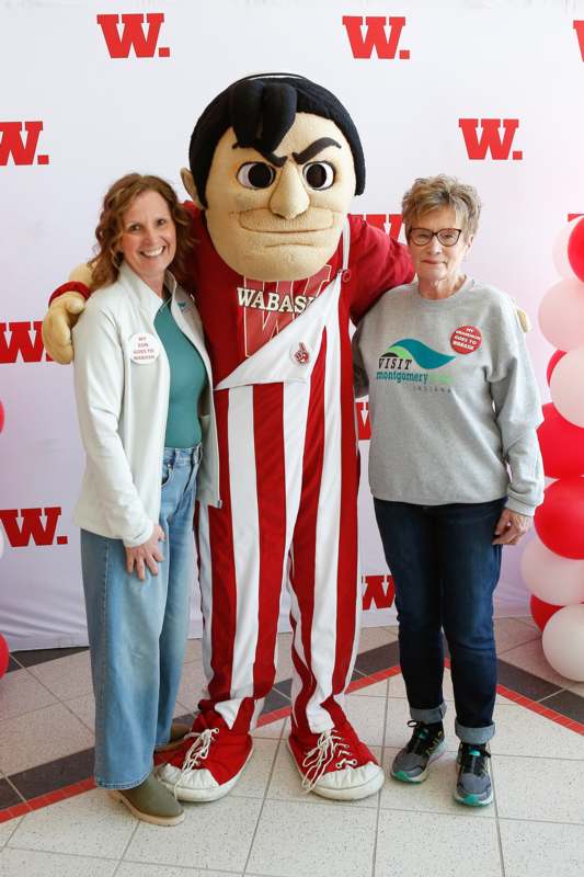 two women standing next to a person in a garment