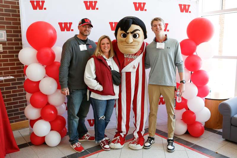 a group of people posing for a photo with a mascot