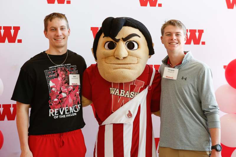 a group of men posing with a mascot