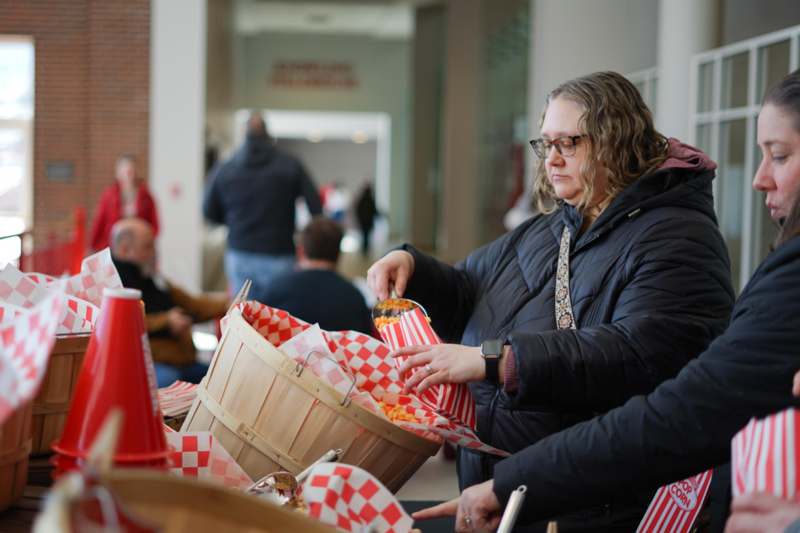 a woman holding a bucket of popcorn