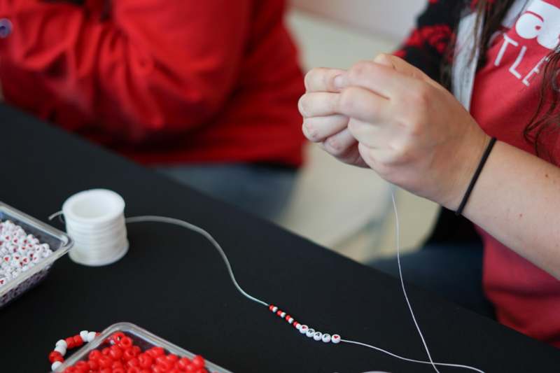 a person sewing a bead