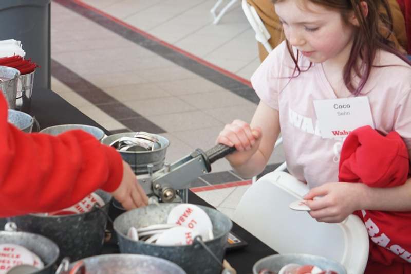 a girl holding a spoon in a bucket