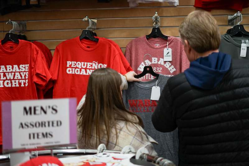 a man and woman looking at t-shirts