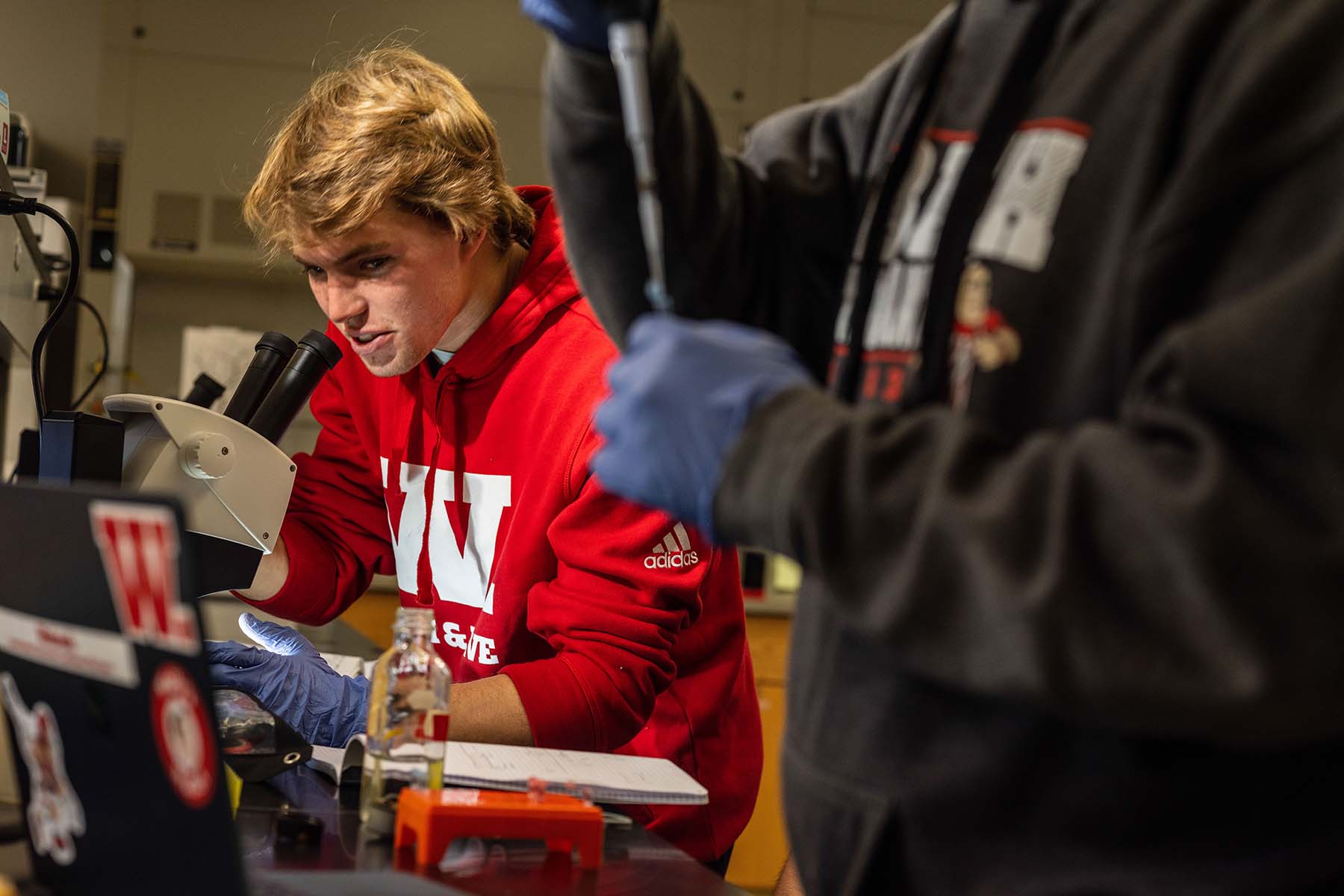 a student checking a sample in a microscope